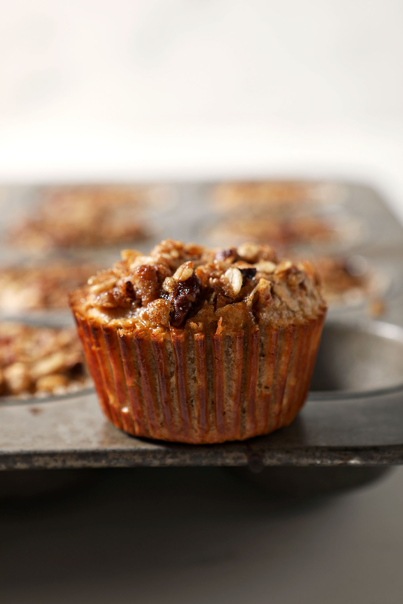 An oatmeal cup sits on top of a muffin tin