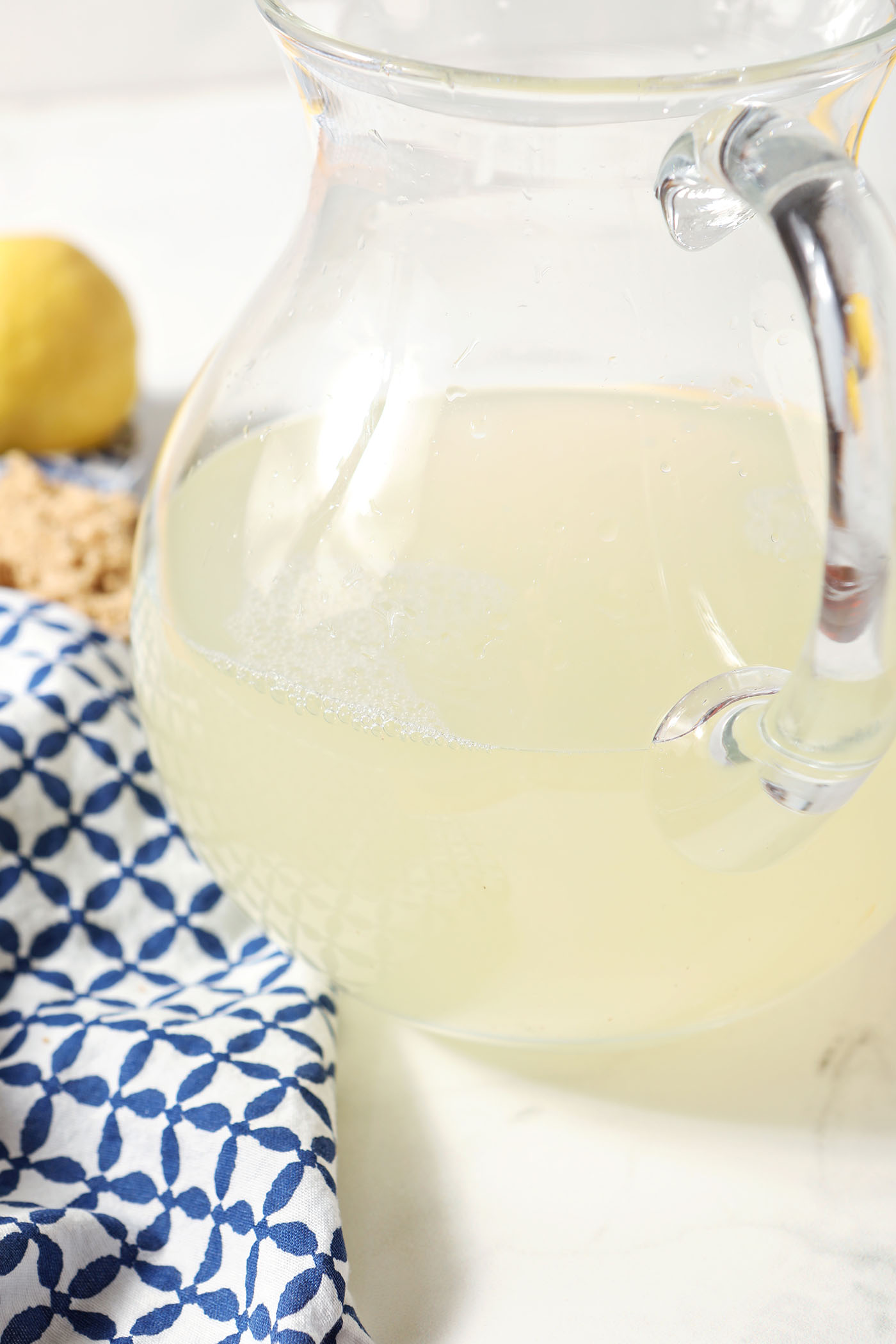 Side angle of lemon juice and water in a pitcher