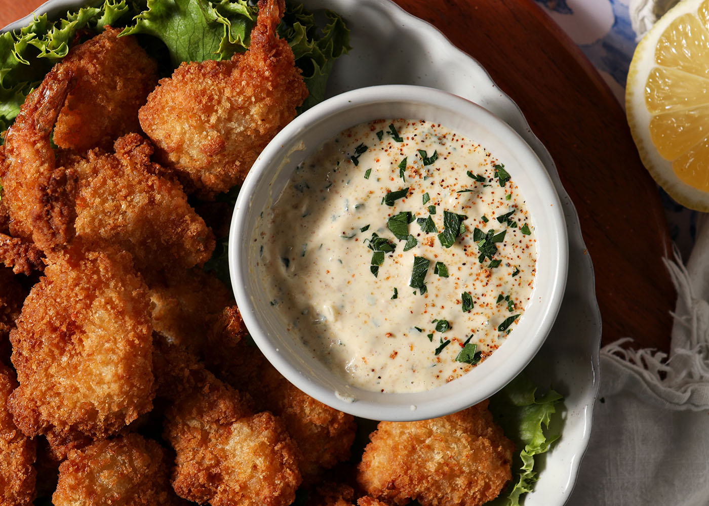 A remoulade in a bowl next to fried shrimp
