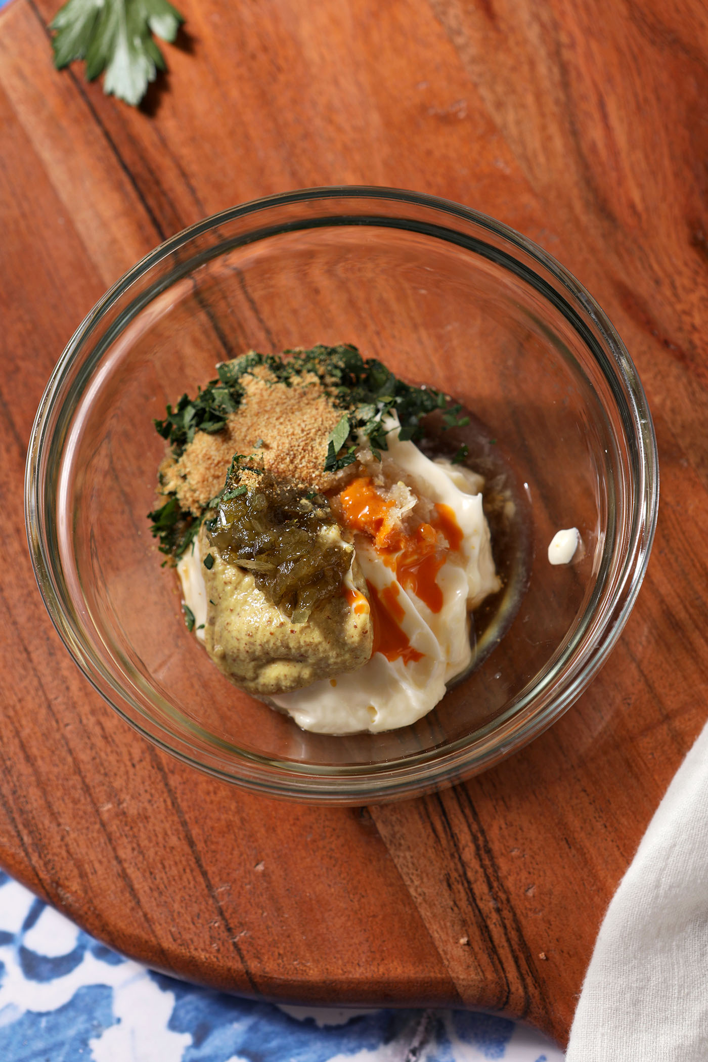 Overhead of a bowl containing ingredients for a Remoulade before mixing.