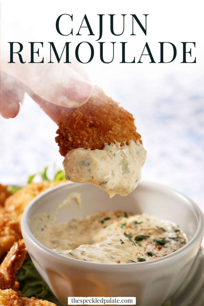 a plate of fried shrimp surrounding the cajun remoulade sauce cup with a shrimp dipped into the cajun remoulade sauce. With text at the top saying "Cajun Remoulade"