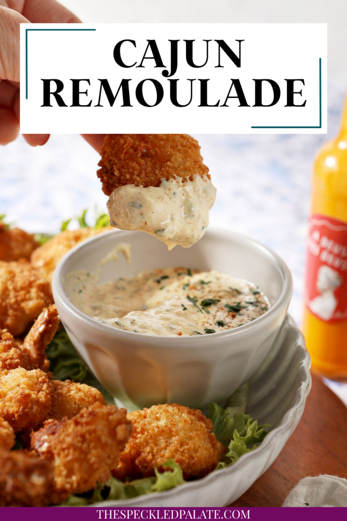 a plate of fried shrimp surrounding the cajun remoulade sauce cup with a shrimp dipped into the cajun remoulade sauce. With text at the top saying "Cajun Remoulade"