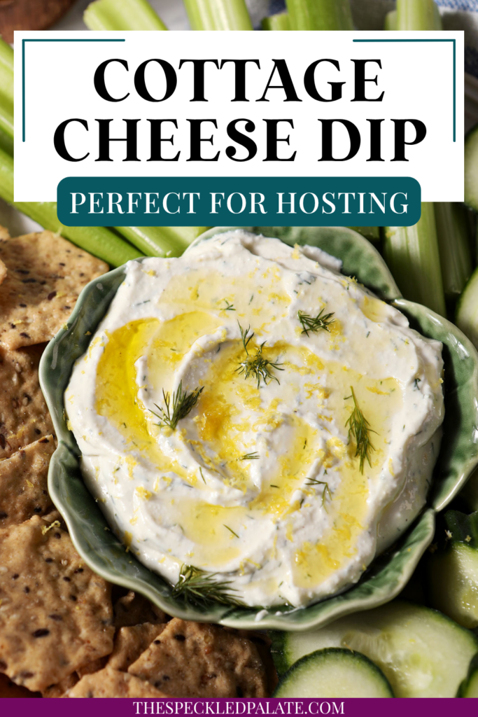 Overhead of Cottage Cheese Dip, garnished with dill, olive oil and lemon zest, on a platter with crackers, cucumber rounds and celery sticks with the text cottage cheese dip perfect for hosting