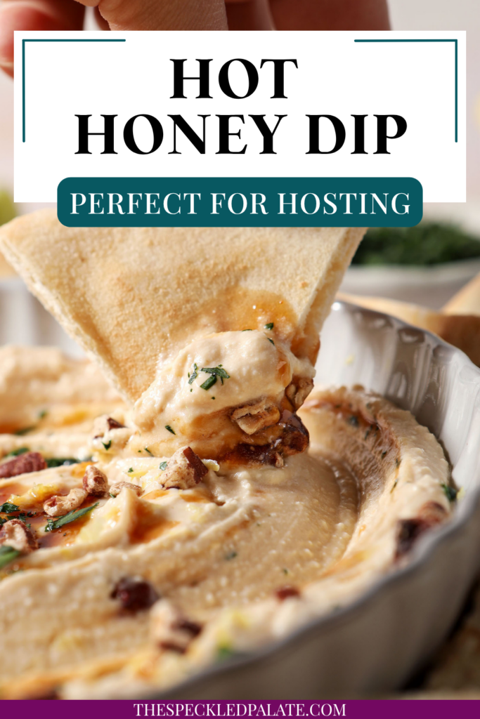 A pita triangle holds a bite of hot honey dip above a platter.