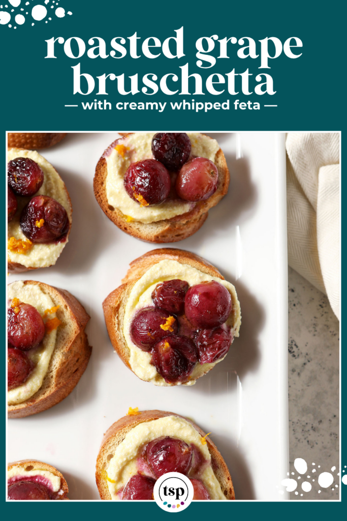 Side angle of Roasted Grape Bruschetta with Whipped Feta on a white platter