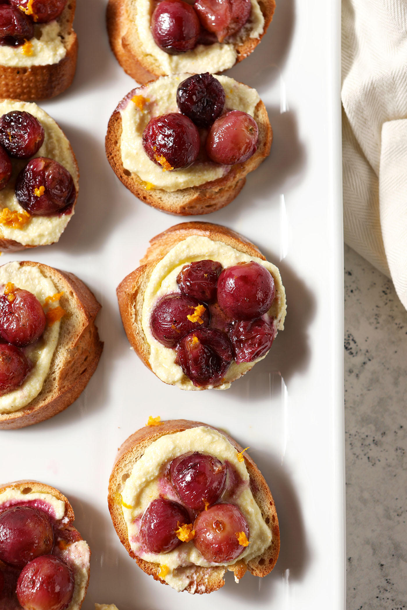 Roasted Grape Bruschetta with Whipped Feta from above on a white serving platter