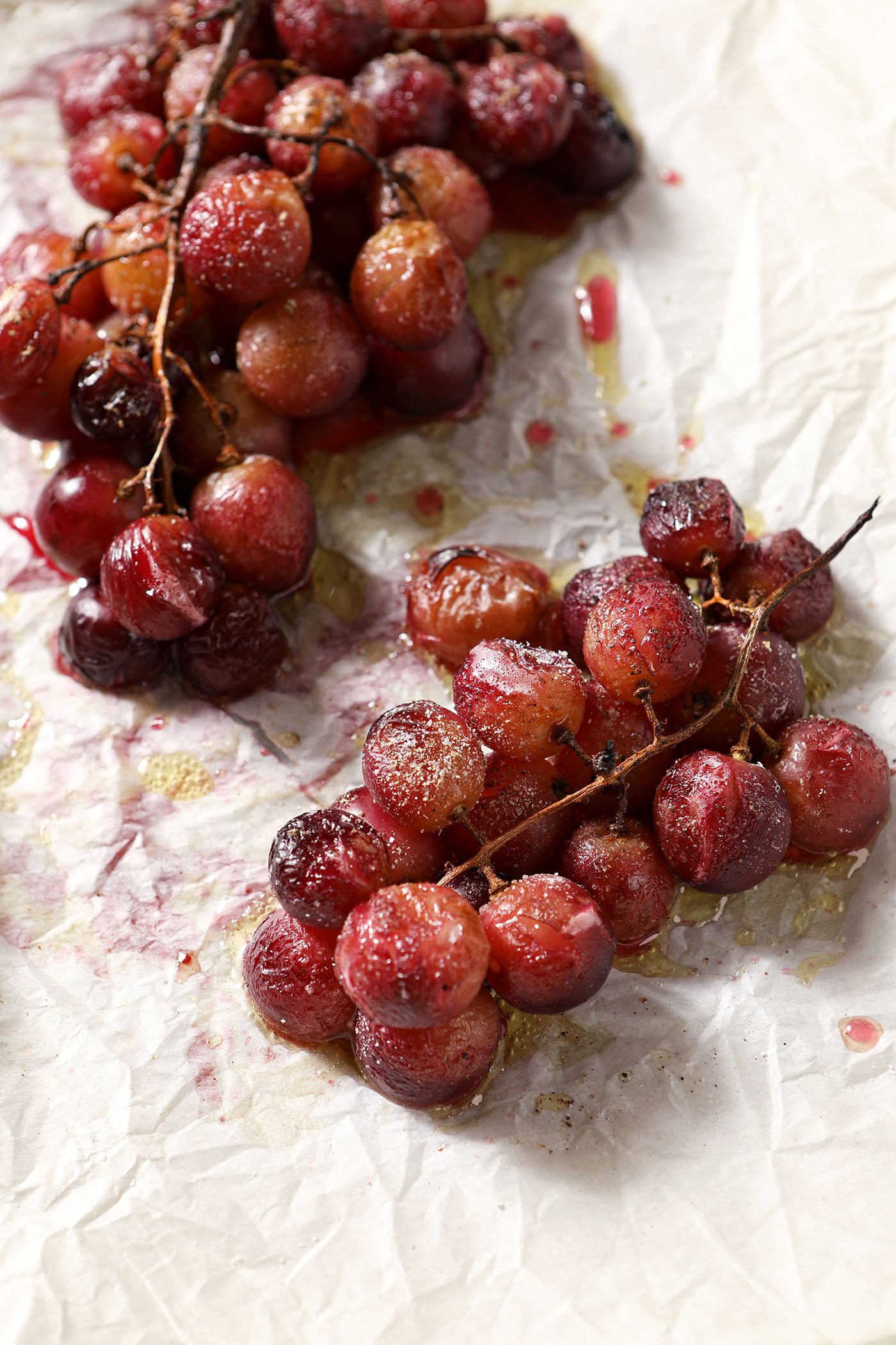 Roasted grapes on parchment on a sheet pan