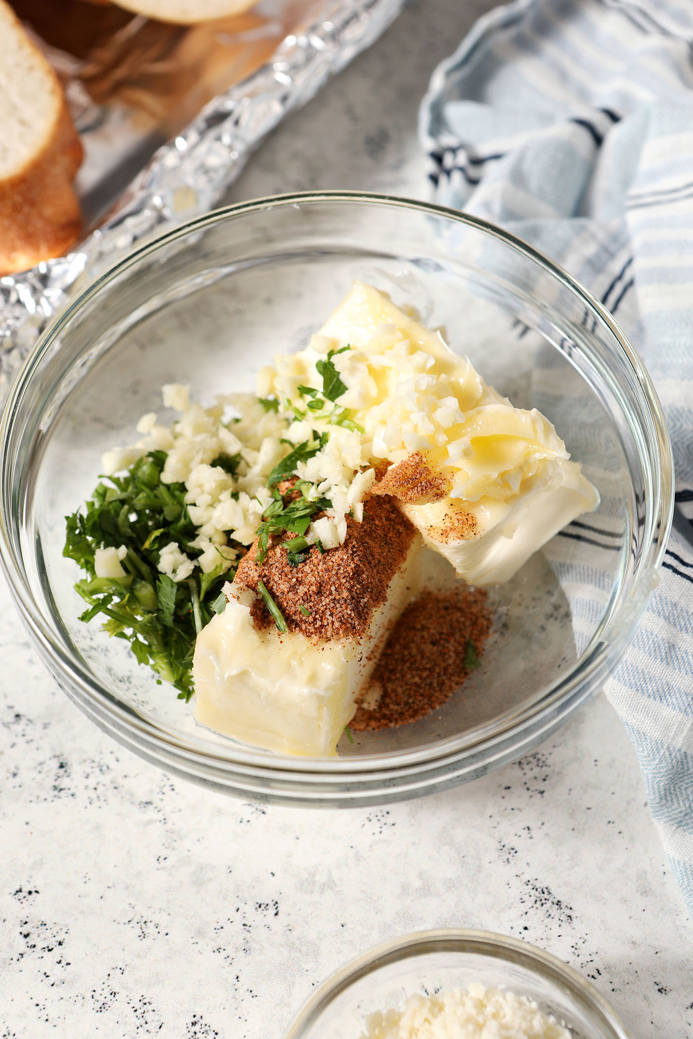 Butter in a bowl with minced garlic, parsley and Cajun seasoning