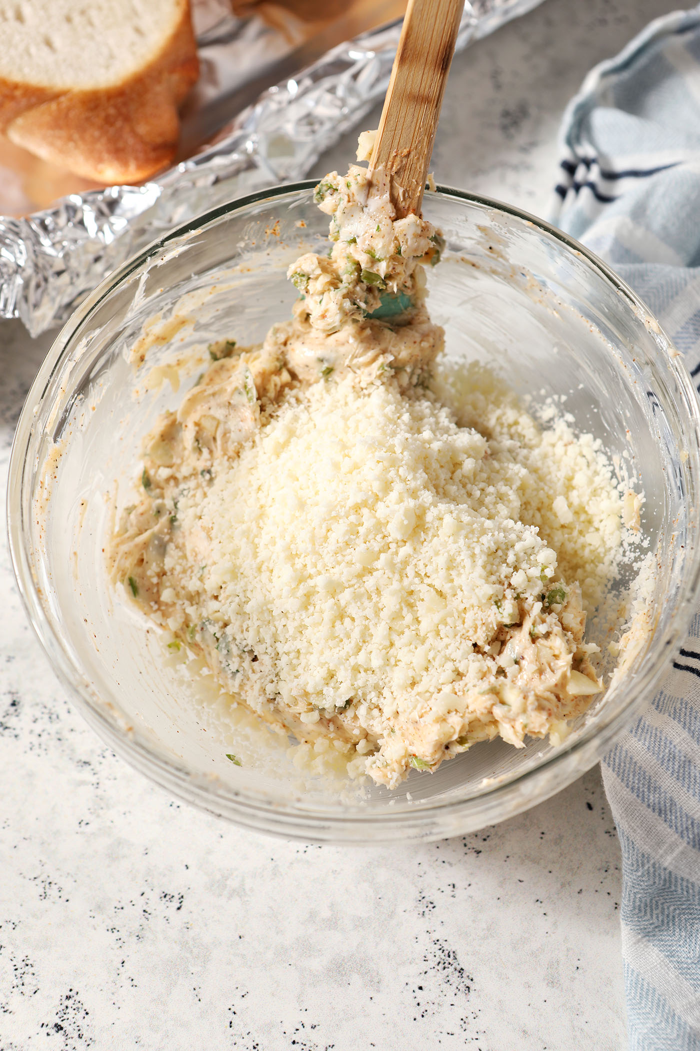 Grated Parmesan cheese on top of compound butter in a bowl before mixing