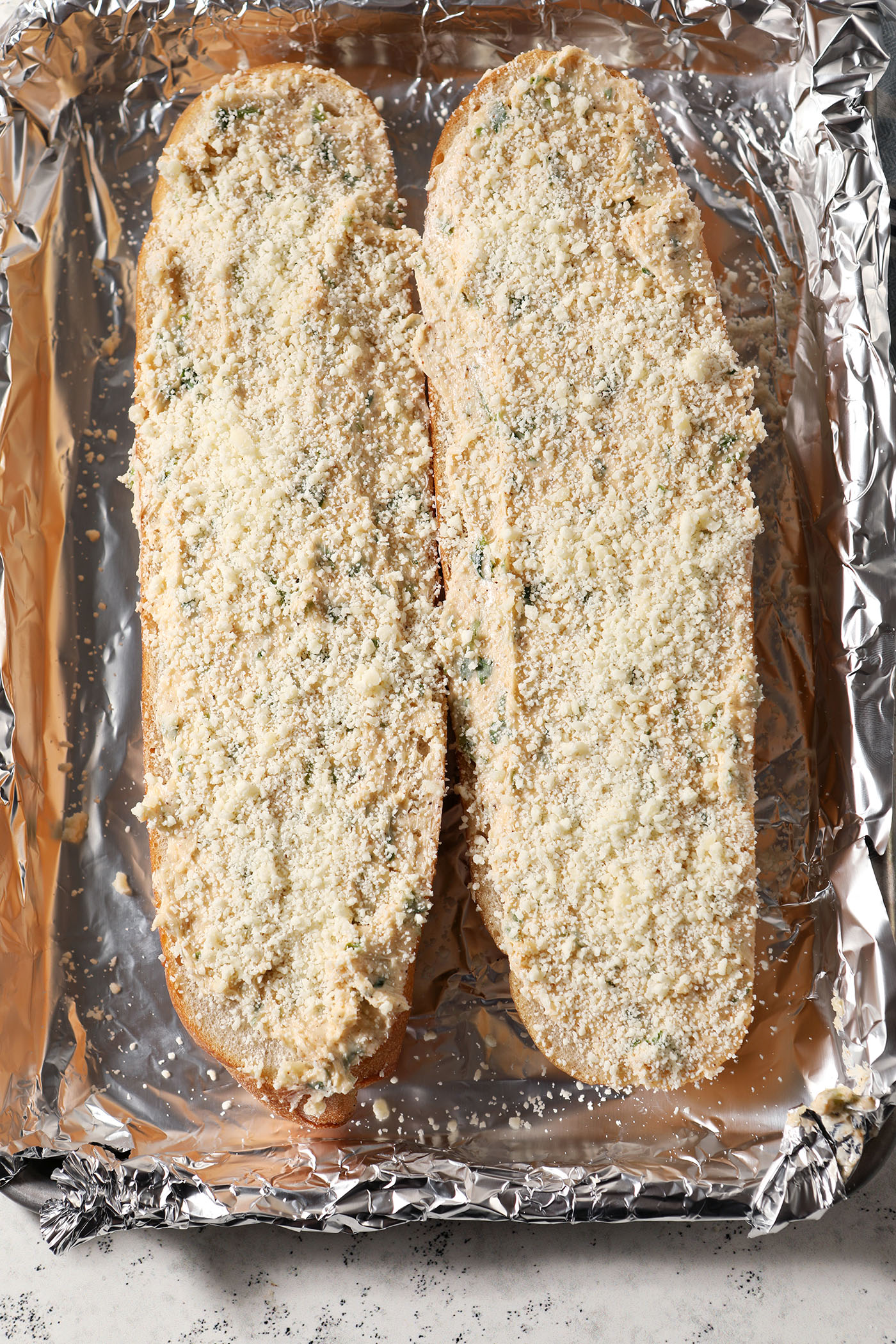 Bonus grated parmesan on Cajun garlic bread on a sheet pan lined with foil