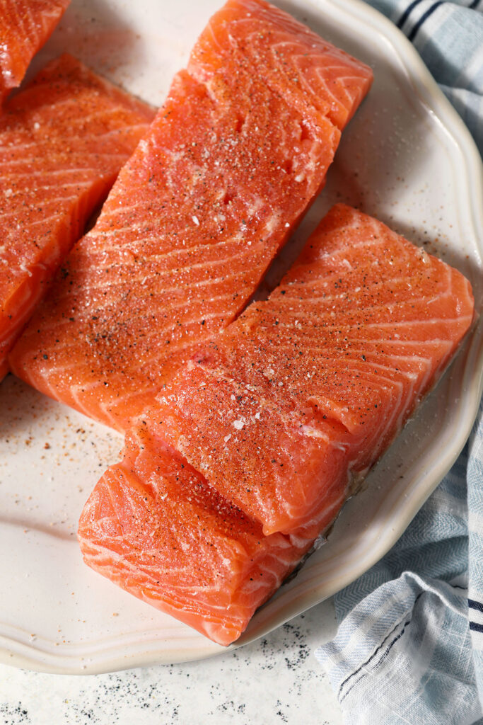 Seasoned salmon on a plate before cooking