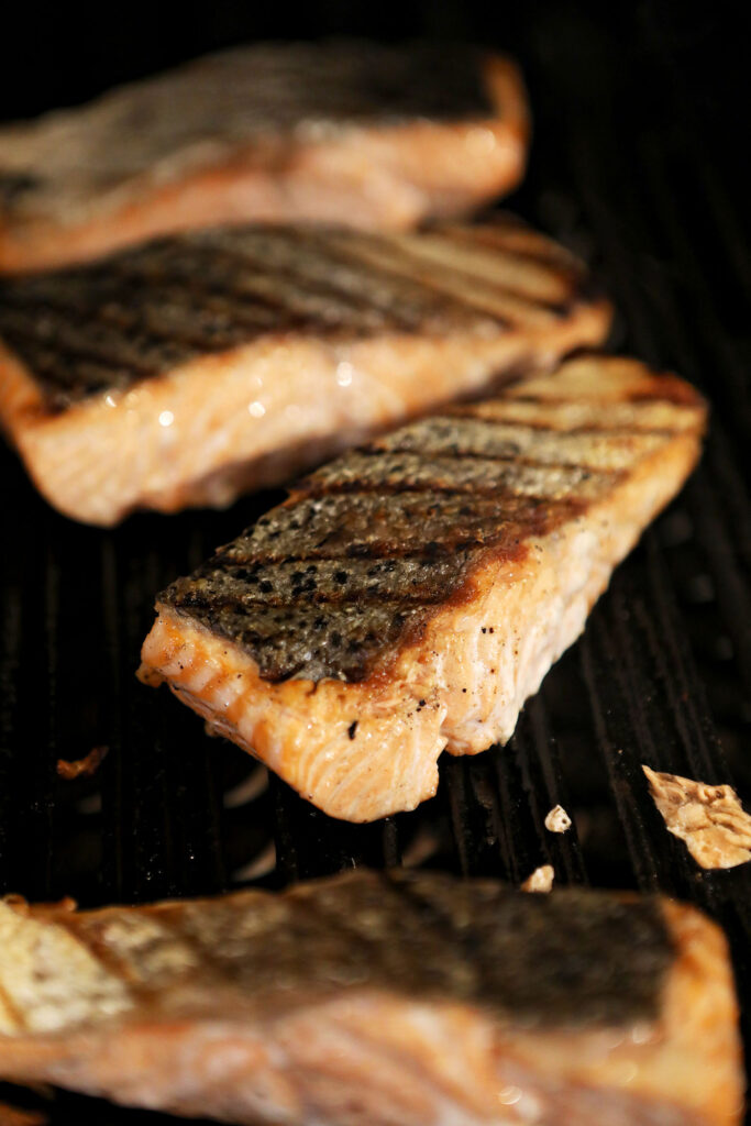 Grilled salmon skin facing up on a grill