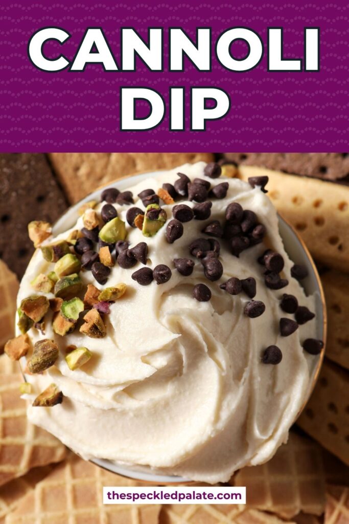 Sweet Cannoli Dip garnished with chopped pistachios and miniature chocolate chips in the middle of various dippers on a platter with the text cannoli dip