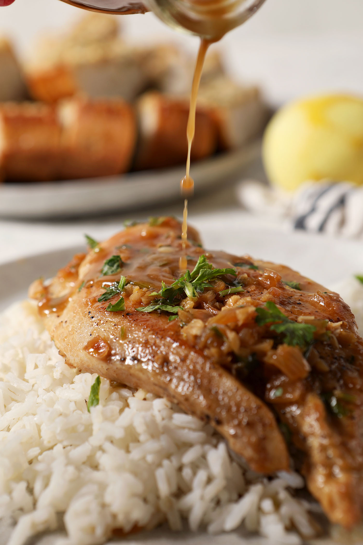 Sauce drizzles on top of a slice of Lemon Garlic Chicken
