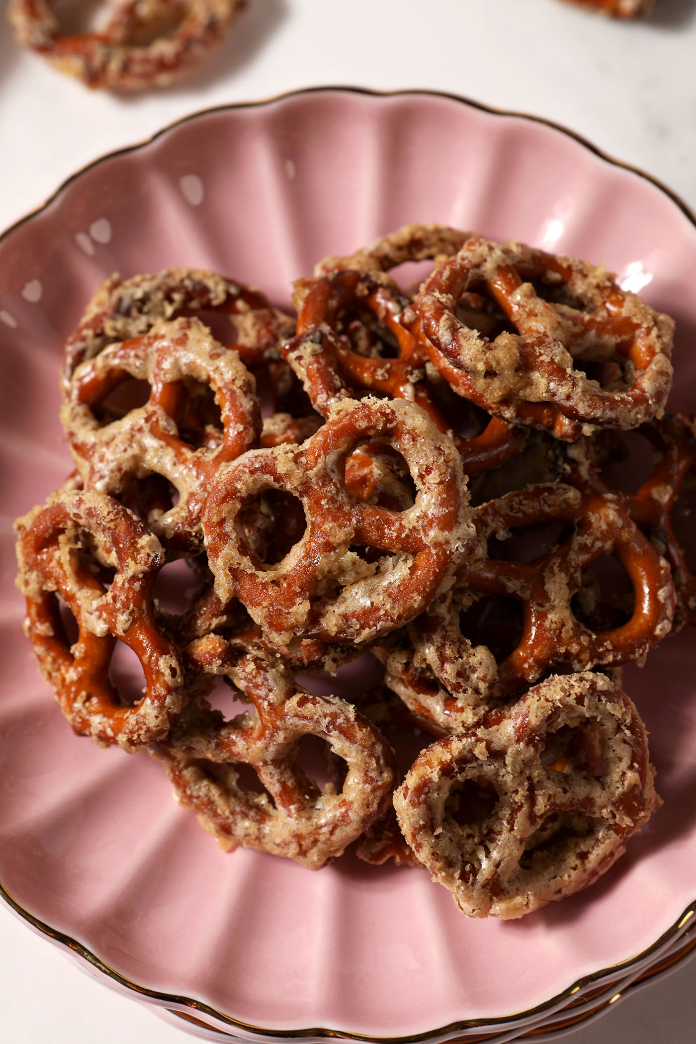 Overhead of Butter Toffee Pretzels on a pink scalloped plate