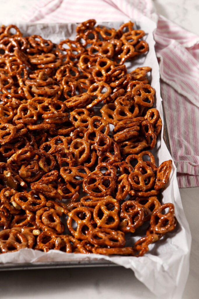 Toffee Pretzels on a sheet pan on a marble surface with a pink striped linen before baking
