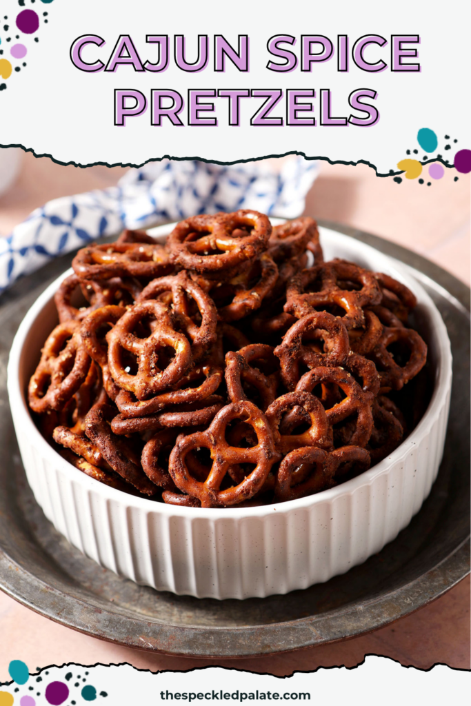 Close-up of Cajun pretzels in a white bowl on a silver tray with the Pinterest Title, " Cajun Spice Pretzels" on top.