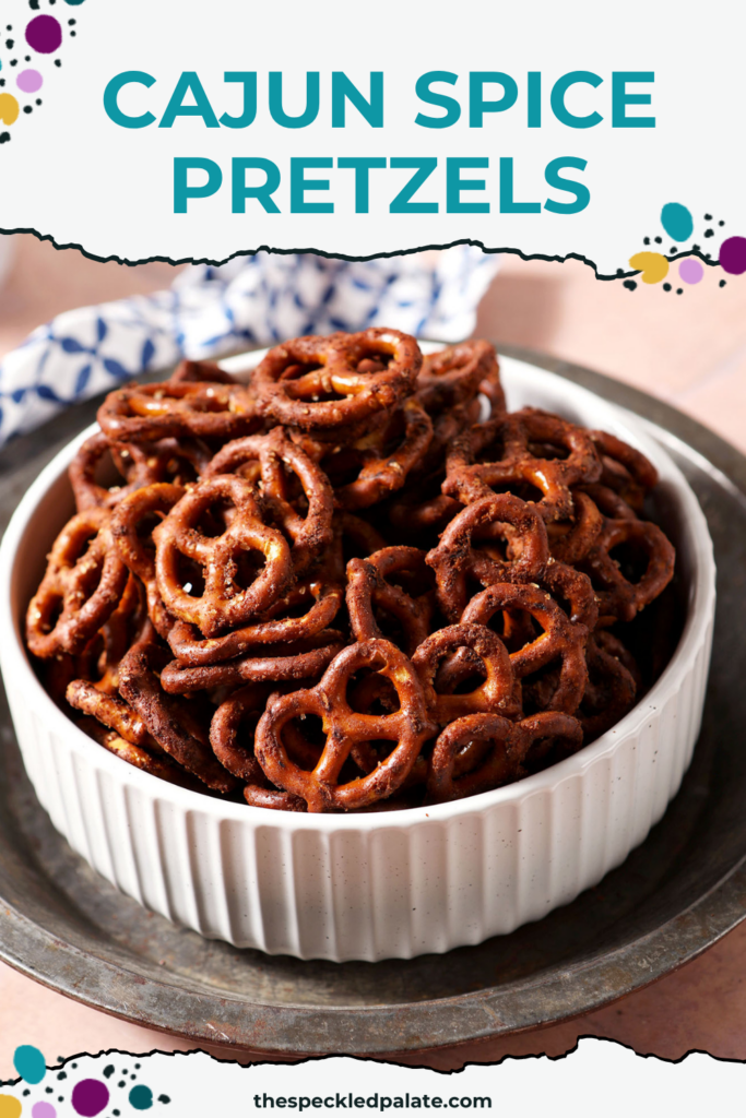 Close-up of Cajun pretzels in a white bowl on a silver tray with the Pinterest Title, " Cajun Spice Pretzels" on top.