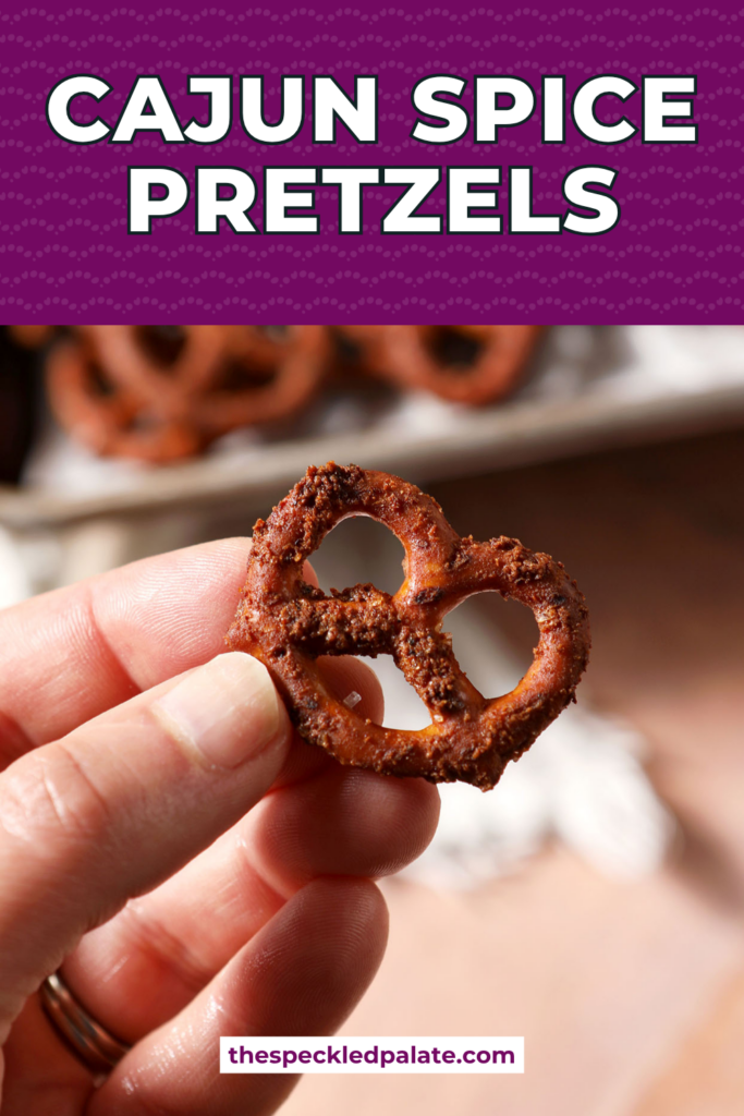 Pretzels tossed in a Cajun spice liquid mixture before baking with the title, " Cajun Spice Pretzels" on top.