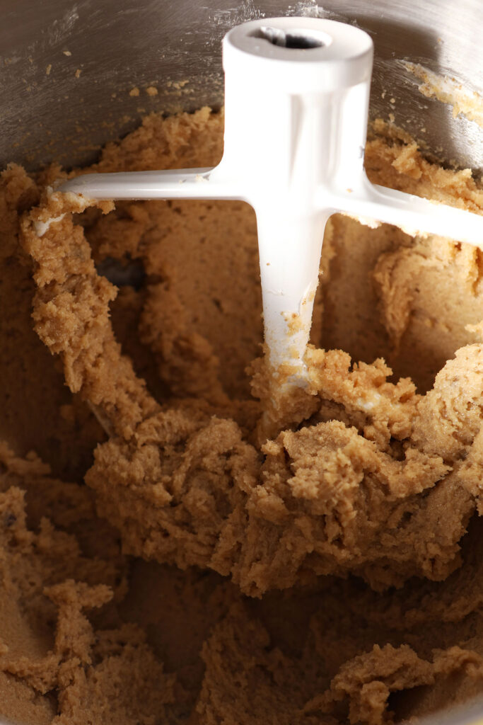 Creamed butter and sugars with a paddle attachment in a bowl