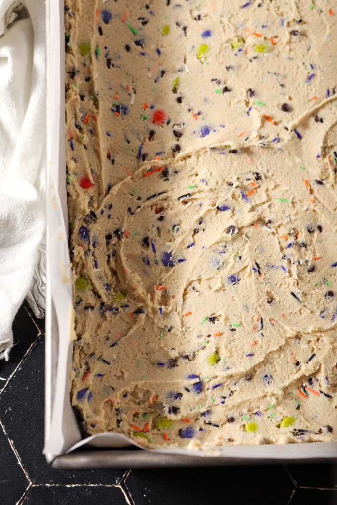 Halloween Cookie Bar cookie dough in a pan before baking