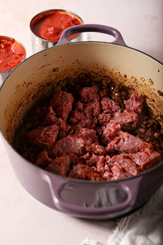 Ground bison in a Dutch oven with vegetables before cooking