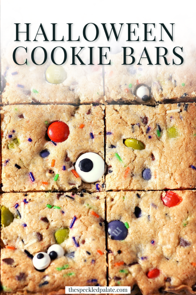 Sliced Halloween Cookie Bars on parchment paper with Pinterest Title, "Halloween Cookie Bars" on top.