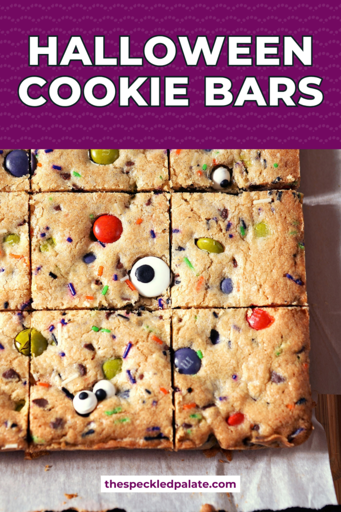 Sliced Halloween Cookie Bars on parchment paper with Pinterest Title, "Halloween Cookie Bars" on top.